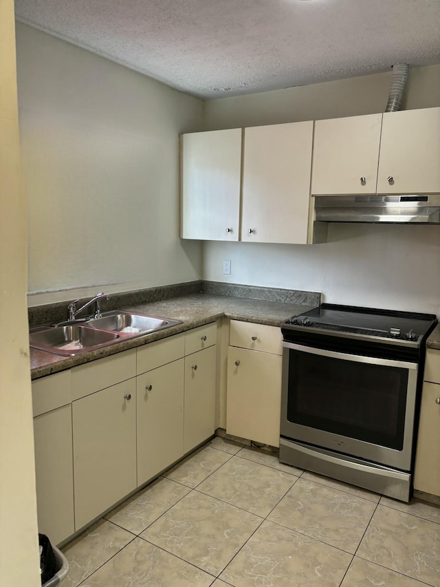 kitchen featuring light tile patterned flooring, sink, stainless steel range with electric cooktop, and a textured ceiling