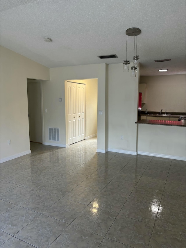 unfurnished room with a textured ceiling