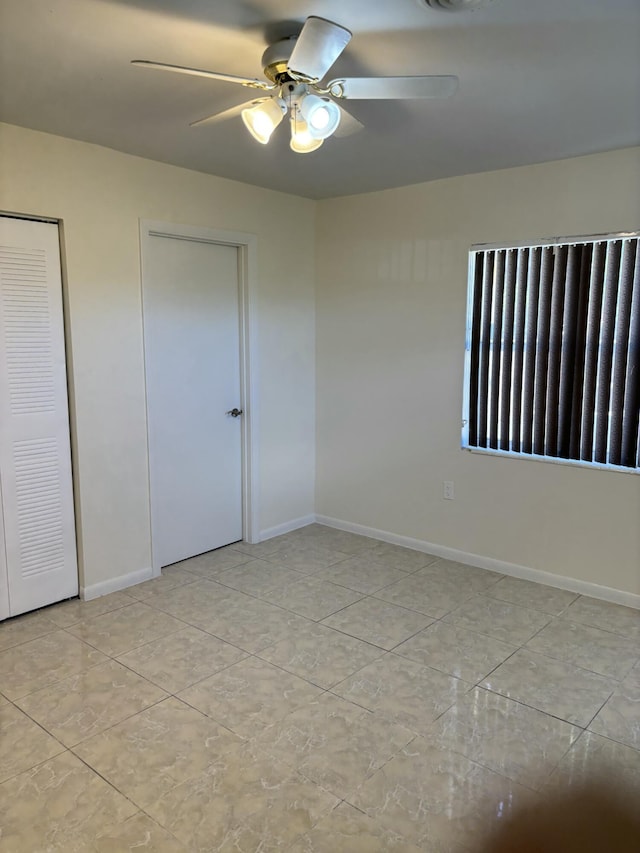 unfurnished bedroom with two closets, light tile patterned floors, and ceiling fan