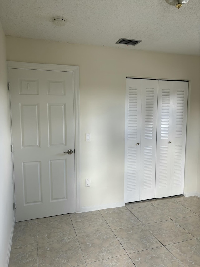 unfurnished bedroom featuring a closet and a textured ceiling