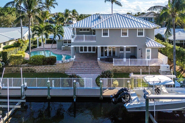 rear view of house with a fenced in pool and a water view