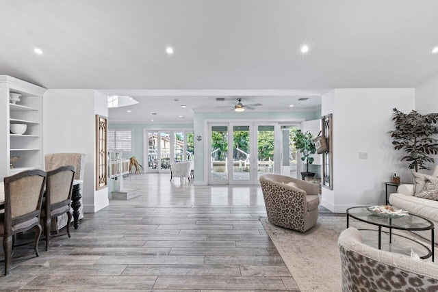 living room featuring french doors, light hardwood / wood-style flooring, and ceiling fan