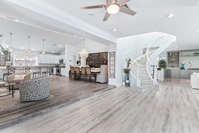 living room with lofted ceiling, ornamental molding, ceiling fan with notable chandelier, and hardwood / wood-style flooring