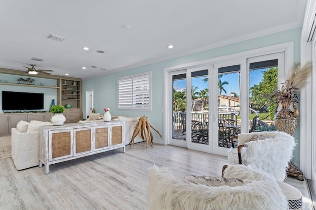 living room with ceiling fan, a healthy amount of sunlight, light hardwood / wood-style floors, and ornamental molding