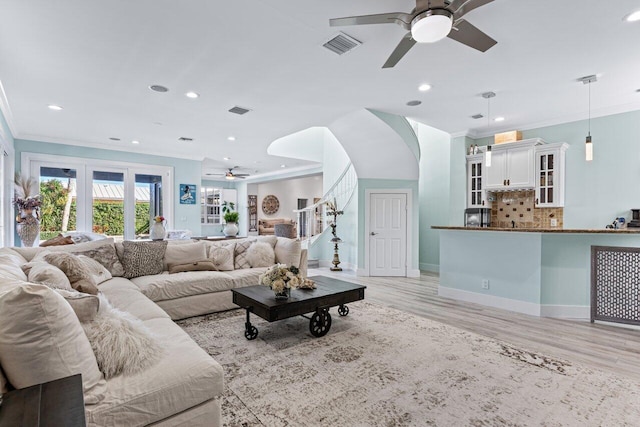 living room with ceiling fan, light hardwood / wood-style floors, and ornamental molding