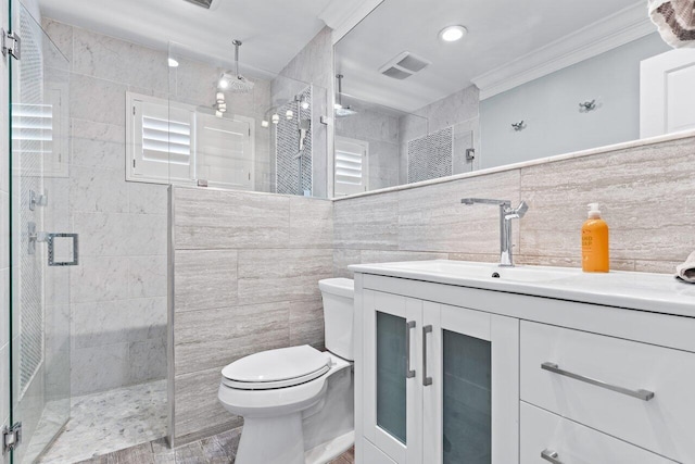 bathroom featuring vanity, crown molding, toilet, tile walls, and walk in shower