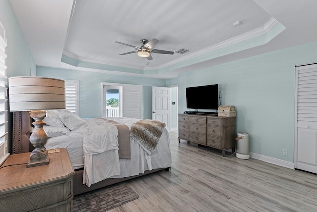 bedroom featuring a raised ceiling, ceiling fan, crown molding, and light hardwood / wood-style floors