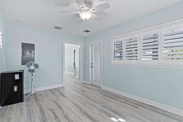 unfurnished room featuring light wood-type flooring, electric panel, and ceiling fan