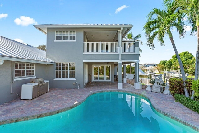 back of house with a patio area, a balcony, and french doors