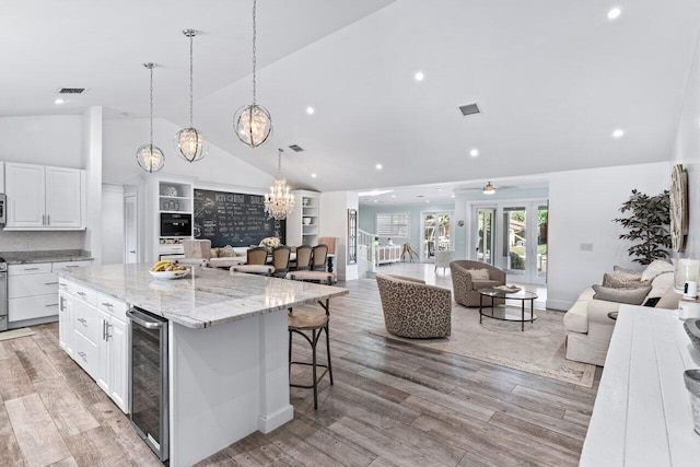 kitchen featuring wine cooler, a spacious island, white cabinets, and light hardwood / wood-style floors