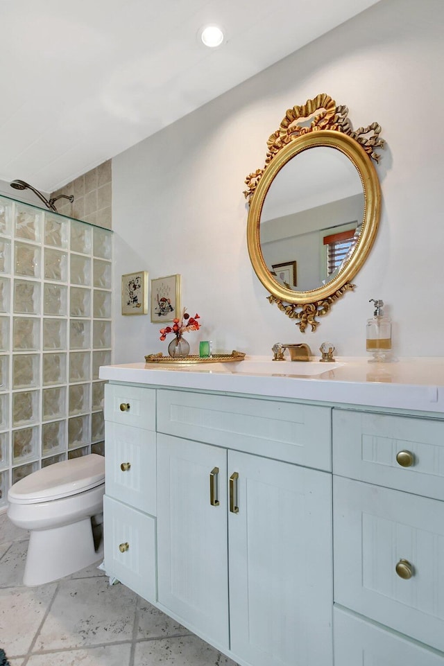 bathroom featuring recessed lighting, vanity, toilet, and a walk in shower