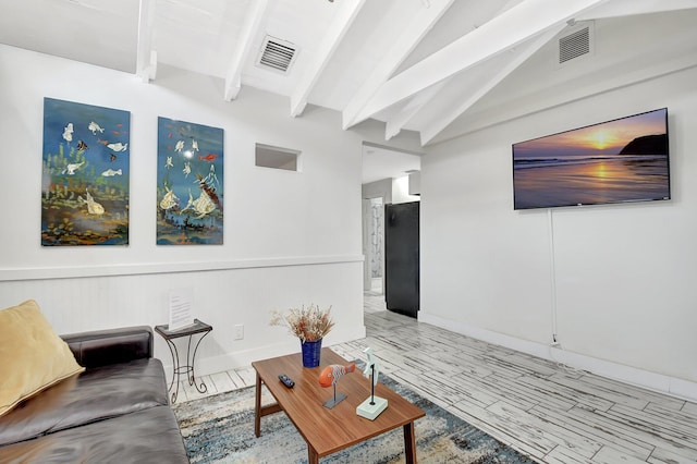 living area with vaulted ceiling with beams, visible vents, and wood finished floors