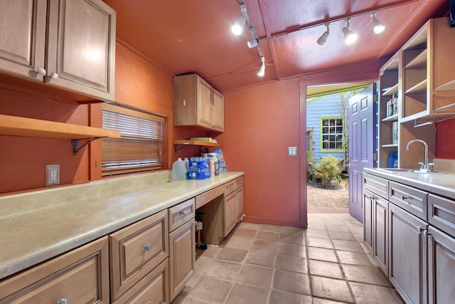 kitchen featuring light countertops, a sink, built in desk, and open shelves