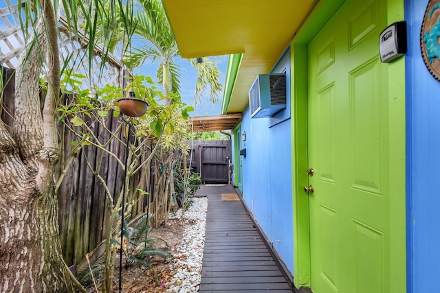 view of side of property featuring a wall mounted air conditioner and fence