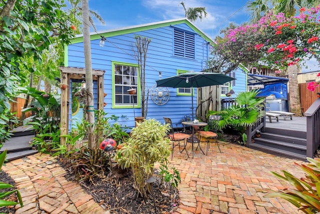 back of property with a patio, a wooden deck, and fence