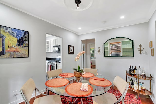 dining room with baseboards, recessed lighting, wood finished floors, and crown molding