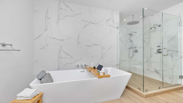 bathroom featuring hardwood / wood-style floors and plus walk in shower