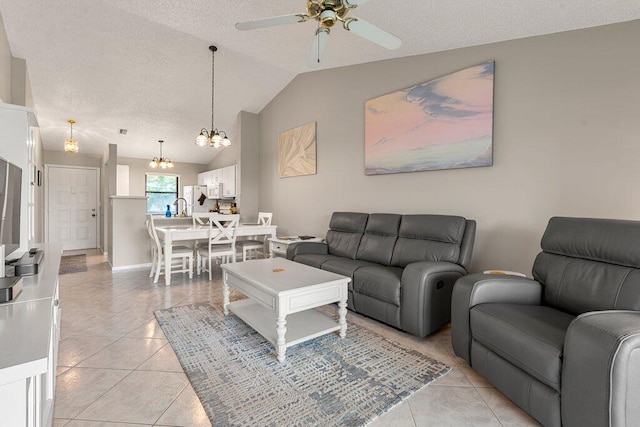 tiled living room featuring ceiling fan with notable chandelier, a textured ceiling, sink, and lofted ceiling