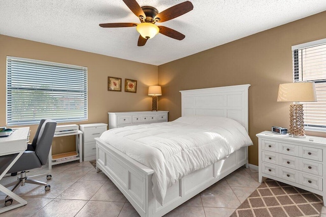bedroom featuring a textured ceiling, ceiling fan, and light tile patterned floors
