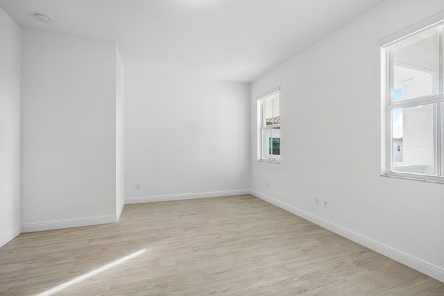 empty room featuring a healthy amount of sunlight and light hardwood / wood-style flooring