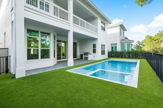 back of house featuring a fenced in pool, a patio area, a yard, and a balcony