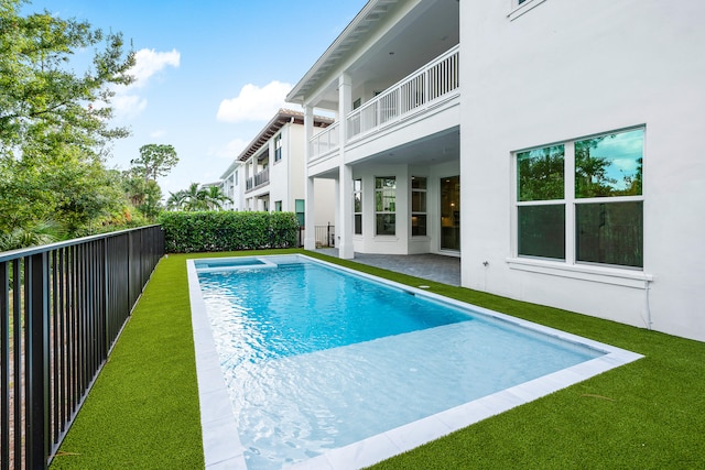 view of pool with a patio and a lawn