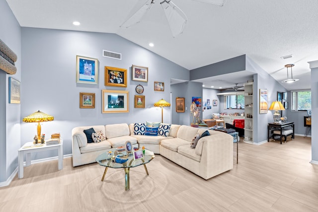 living room featuring a textured ceiling, lofted ceiling, and ceiling fan