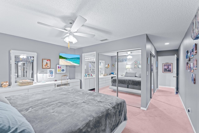 carpeted bedroom featuring a textured ceiling and ceiling fan