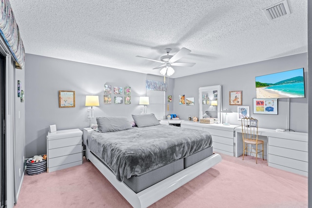 bedroom with carpet, a textured ceiling, built in desk, and ceiling fan