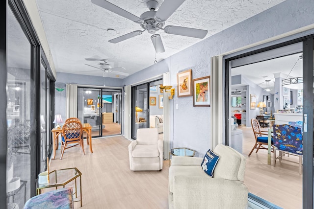 living room featuring a textured ceiling, hardwood / wood-style flooring, and ceiling fan