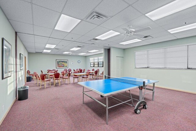 recreation room with a paneled ceiling, carpet, and ceiling fan