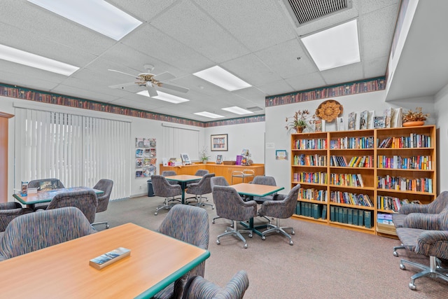 carpeted office featuring a drop ceiling and ceiling fan