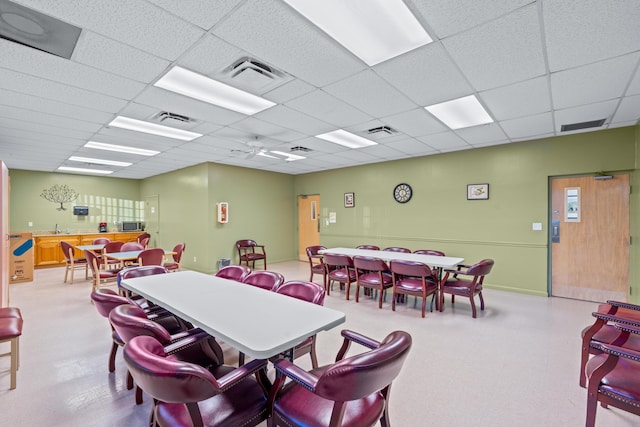 dining space featuring a paneled ceiling and sink