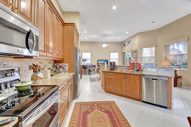 kitchen featuring stainless steel appliances, light tile patterned floors, backsplash, and light stone counters