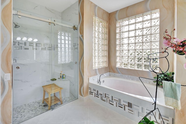 bathroom featuring plus walk in shower, tile patterned flooring, and a healthy amount of sunlight