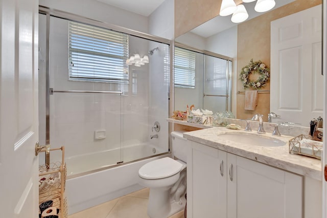 full bathroom with combined bath / shower with glass door, vanity, tile patterned floors, and a healthy amount of sunlight