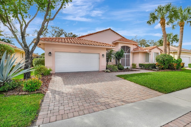 mediterranean / spanish house featuring a garage and a front yard