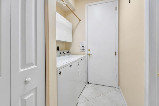 laundry area featuring cabinets, washer and dryer, and light tile patterned flooring