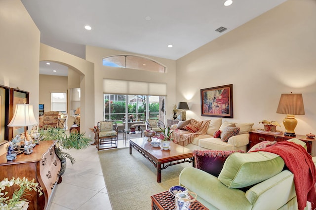 living room featuring light tile patterned floors and a towering ceiling