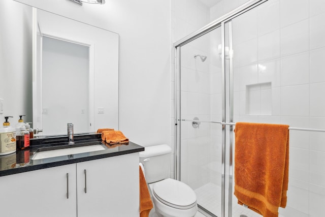 full bath featuring vanity, a shower stall, and toilet