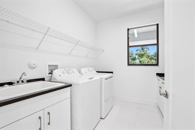 laundry room featuring independent washer and dryer, a sink, cabinet space, and baseboards