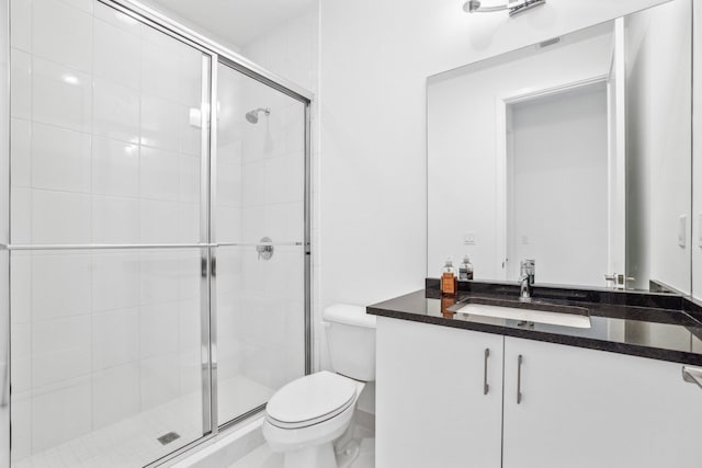 bathroom featuring toilet, a shower stall, and vanity