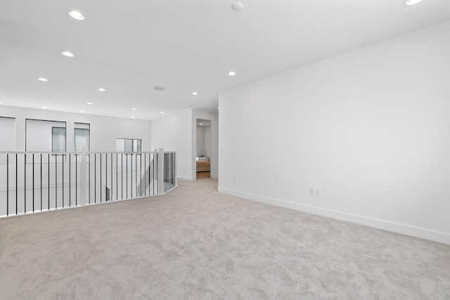 spare room featuring carpet floors, recessed lighting, and baseboards