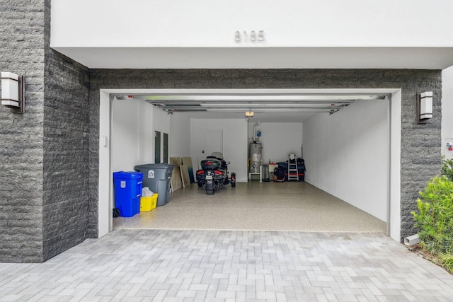 garage with decorative driveway and gas water heater