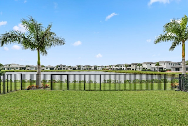 view of yard with a water view, a fenced backyard, and a residential view