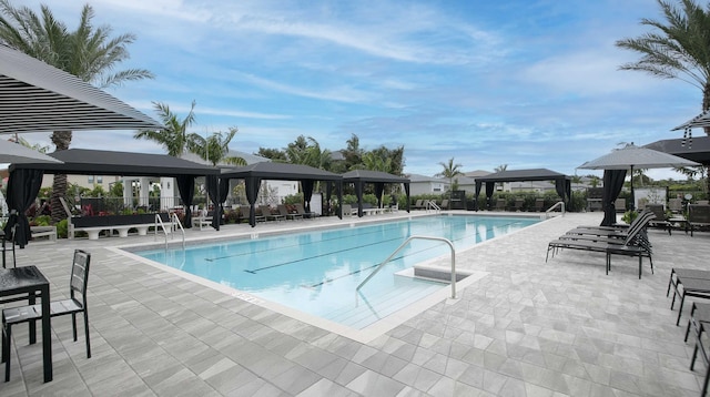 community pool with fence, a patio, and a gazebo