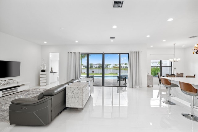 living room with recessed lighting, visible vents, and an inviting chandelier