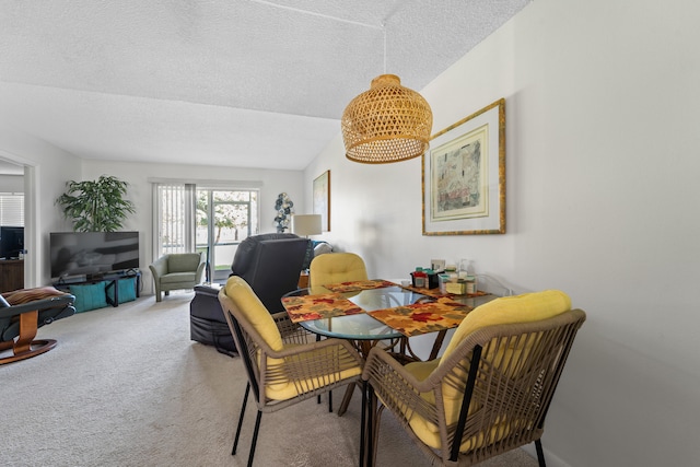 dining space with lofted ceiling, carpet, and a textured ceiling