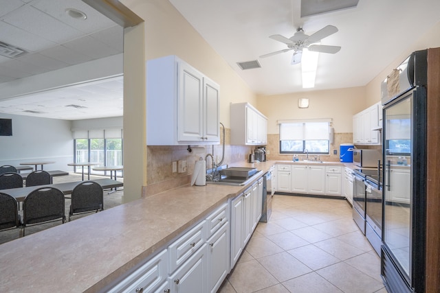 kitchen featuring white cabinets, a healthy amount of sunlight, backsplash, and appliances with stainless steel finishes