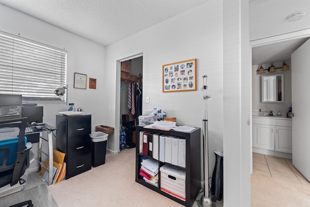 home office with a textured ceiling, carpet floors, and sink